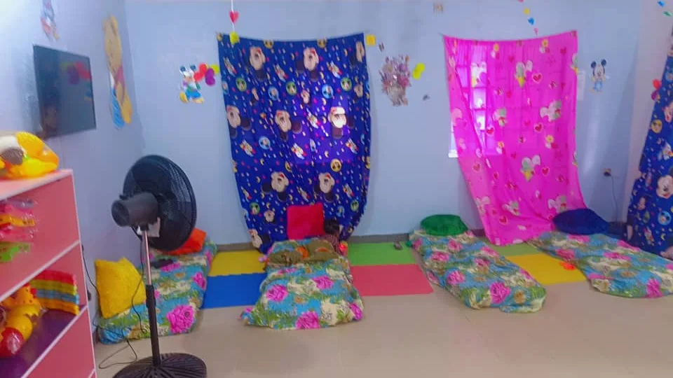 Crèche room with colourful play mats, cushions and rest spaces