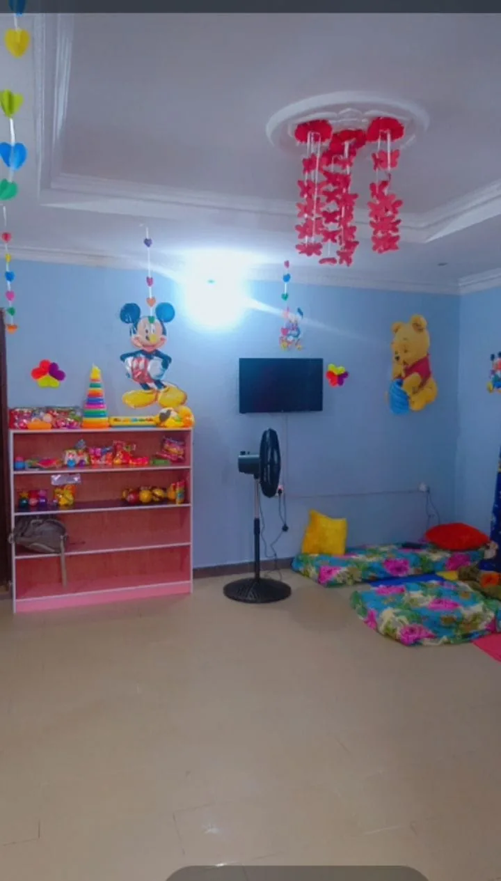 Crèche play area with toys on a shelf and floor mats