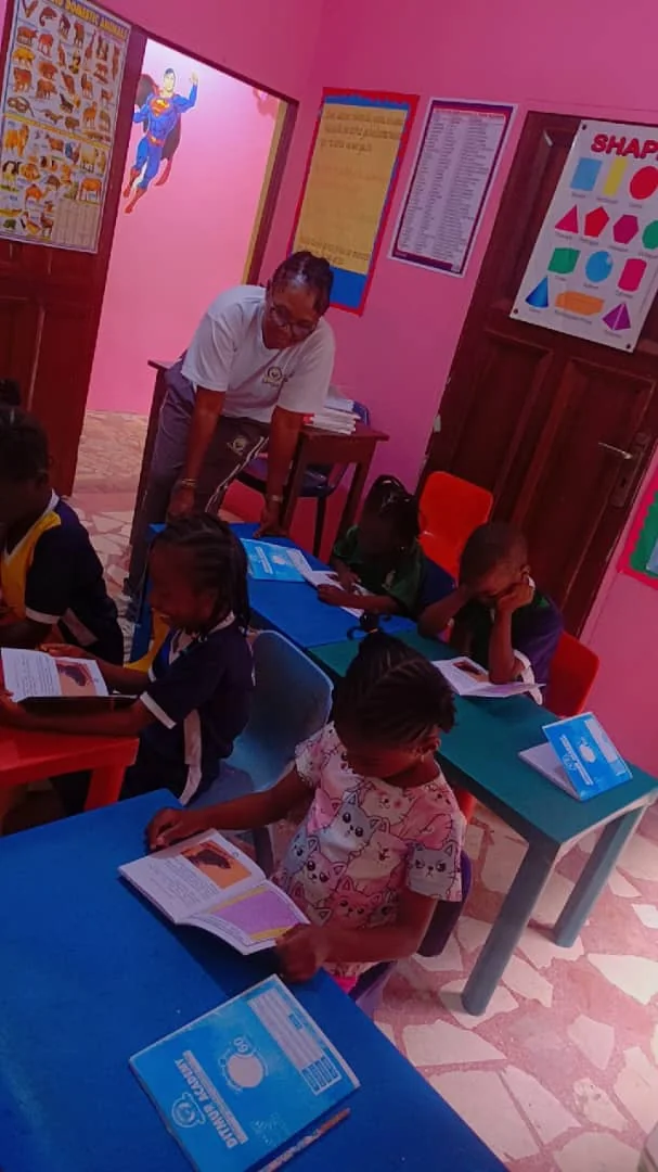 Teacher guiding pupils as they read at classroom tables
