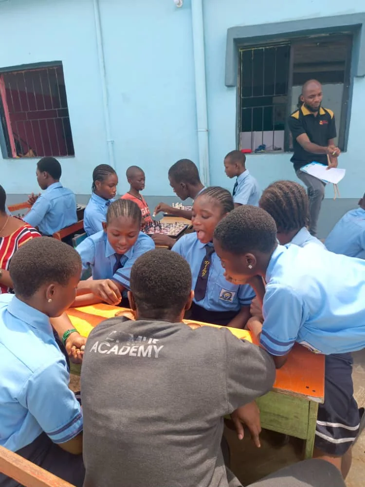 Secondary pupils gathering around classroom chess and strategy games
